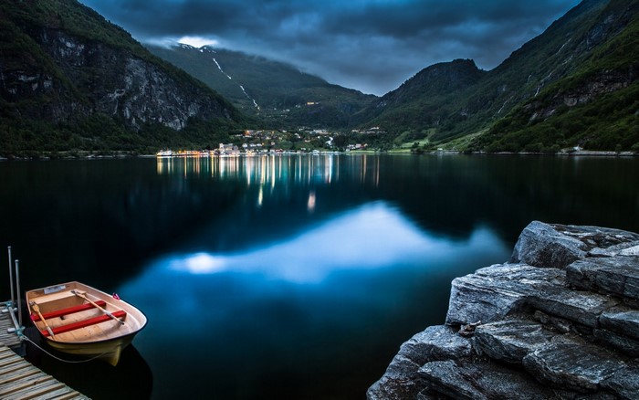 Boat docked on a lake in Geiranger, Norway at dusk