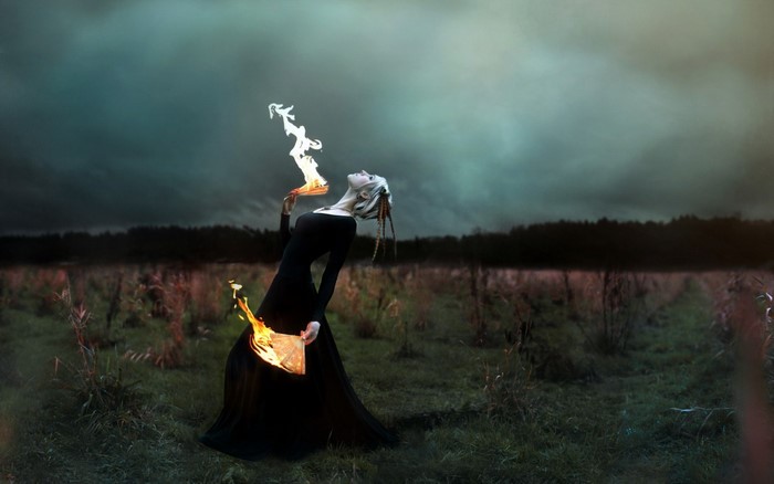 Woman performing fire magic in a field
