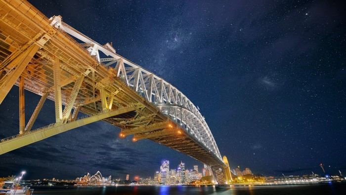 Sydney Harbour Bridge at night with stars and city skyline