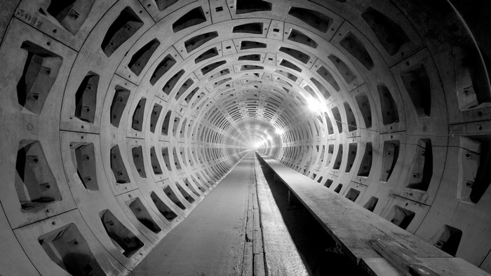 Monochrome tunnel architecture with concrete segments and light