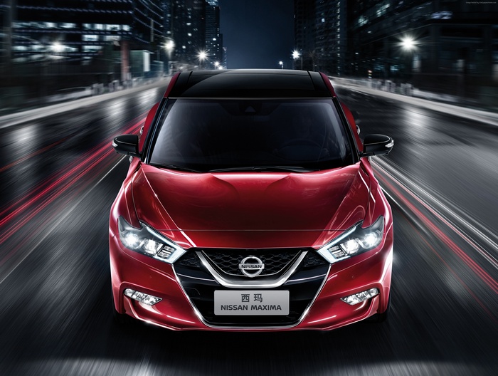 Red Nissan Maxima driving at night