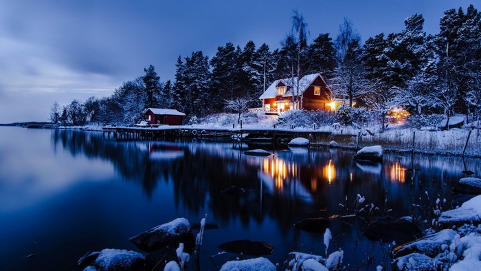 Winter cabin by a lake at dusk