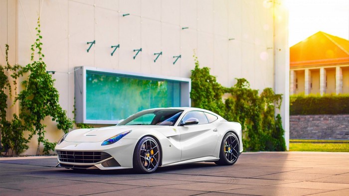 White Ferrari F12berlinetta parked in front of a building