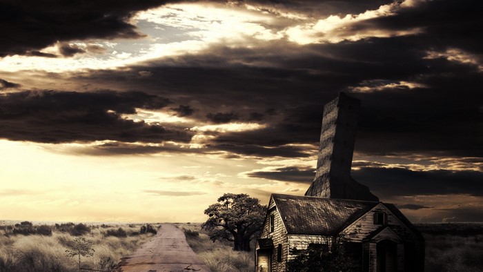 Abandoned house and tower under stormy sky