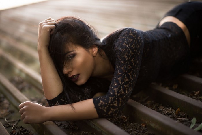 Woman in black lace dress lying down