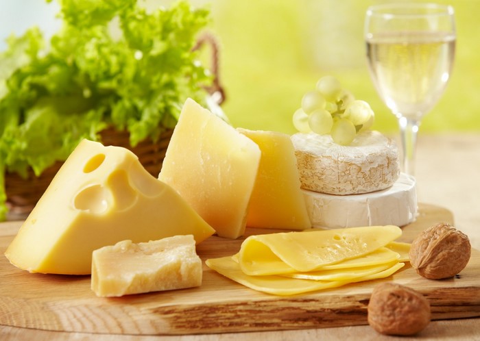 Assortment of cheeses with grapes, walnuts, and white wine