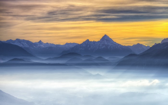 Misty mountains at sunrise with golden sky