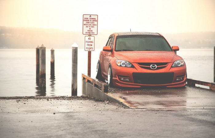 Orange Mazda 3 on a boat ramp