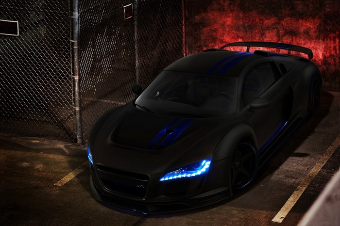 Black Audi R8 with blue accents parked near a fence