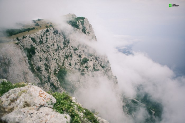 Rocky mountains shrouded in mist over the sea
