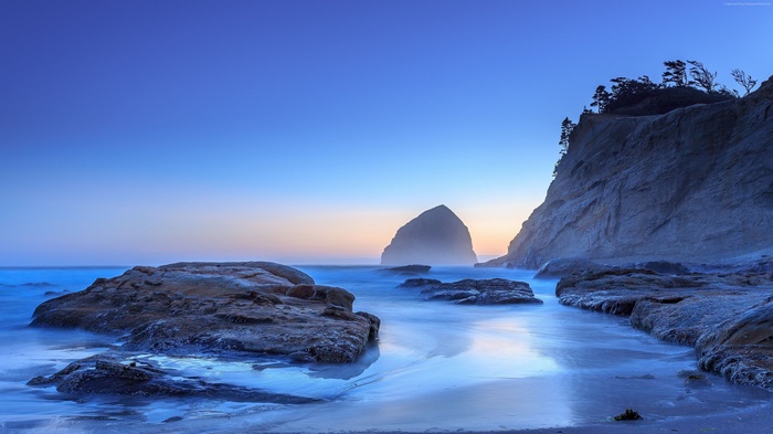 Beach with rock formations and ocean at sunset