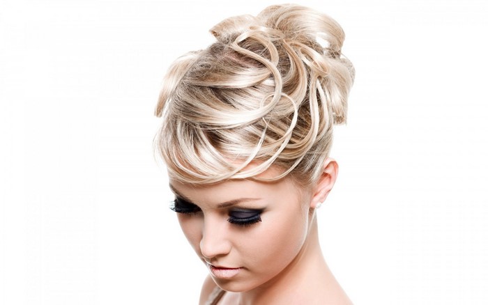 Woman with blonde updo and dramatic makeup
