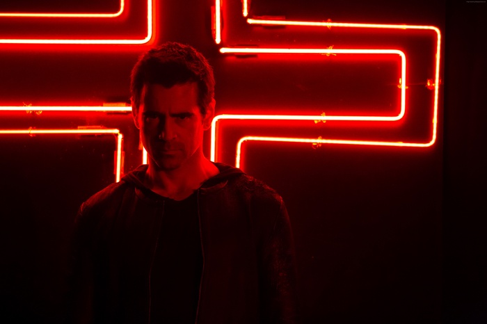 Colin Farrell in front of red neon lights
