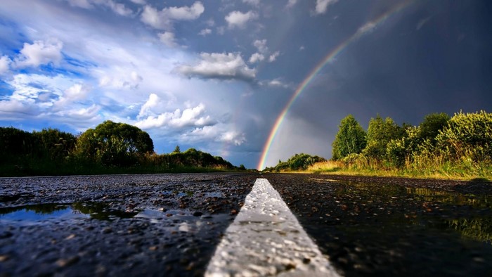 Road with rainbow and clouds after rain
