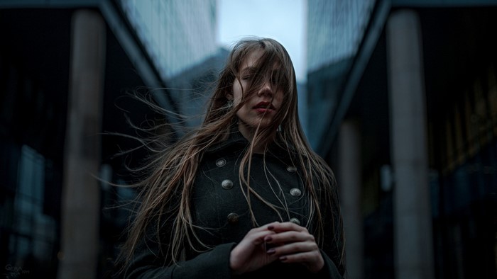 Woman with auburn hair in a dark coat