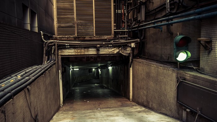Entrance to a dark parking garage with a green traffic light
