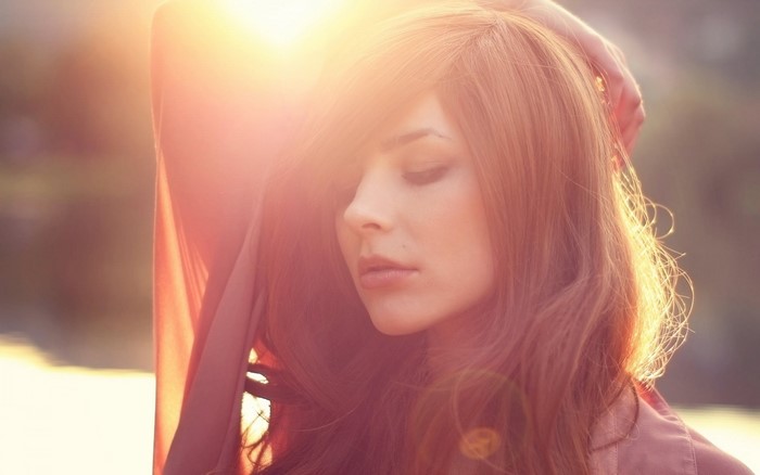 Woman with long red hair in sunlight