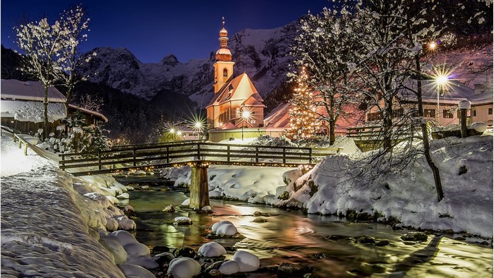 Winter village with church and bridge at night