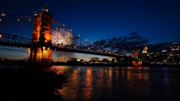 Fireworks over a bridge and city skyline at night