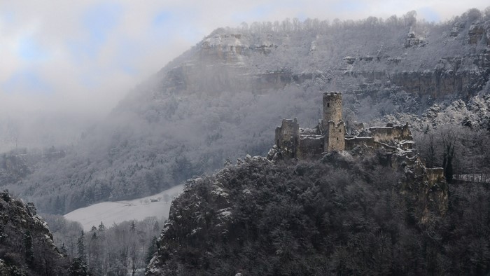 Snow-covered castle ruins on a mountain ridge in winter