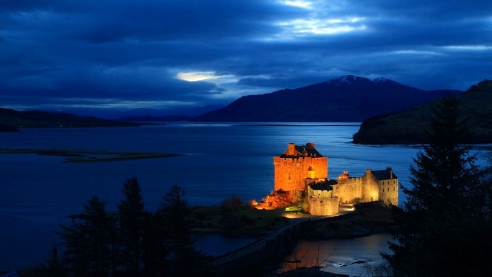 Eilean Donan Castle at night by a loch