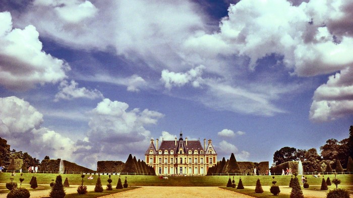 Chateau de Breteuil, France, with manicured gardens and clouds