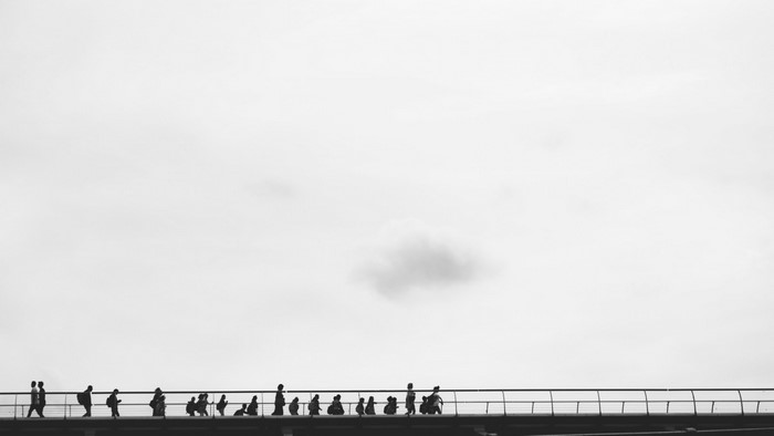People walking on a bridge in monochrome