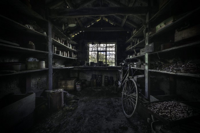 Abandoned storage room with shelves and bicycle