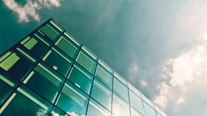 Modern glass building facade against a cloudy sky