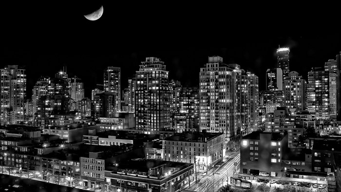 Monochrome cityscape of Vancouver at night with a crescent moon