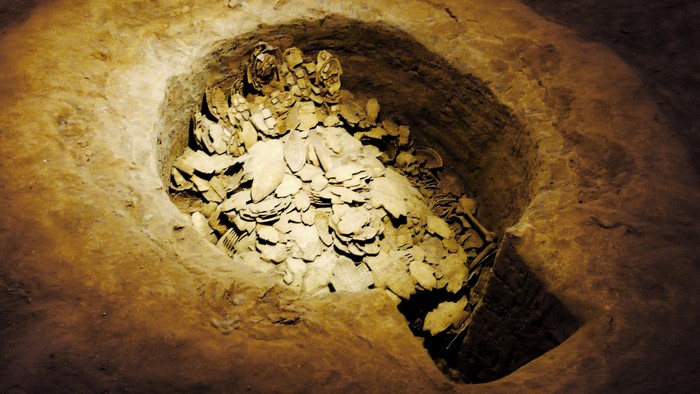 Archaeological excavation of ancient burial site with artifacts