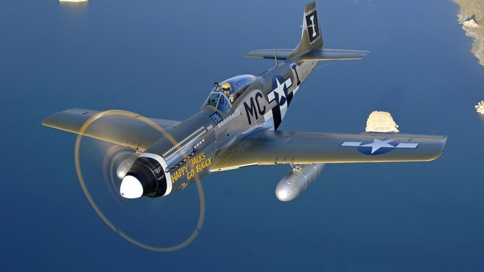 North American P-51 Mustang flying over water