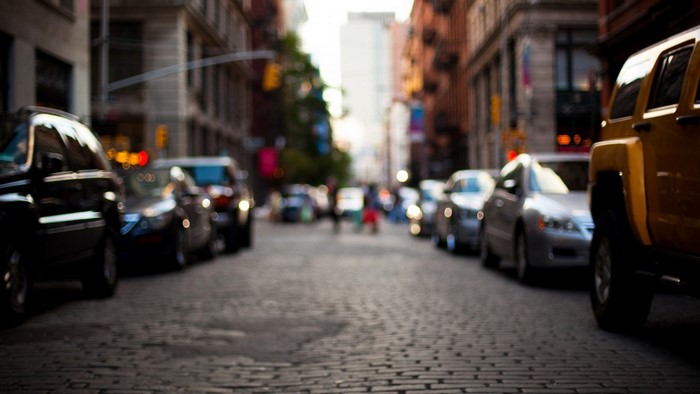 City street with cars and pedestrians at dusk