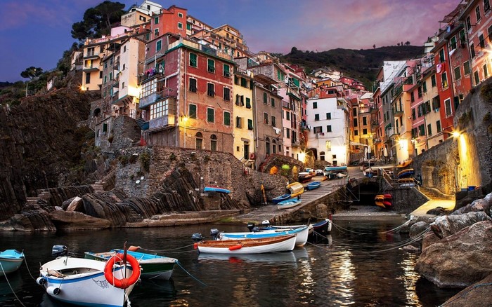 Colorful buildings on a cliffside overlooking a harbor with boats