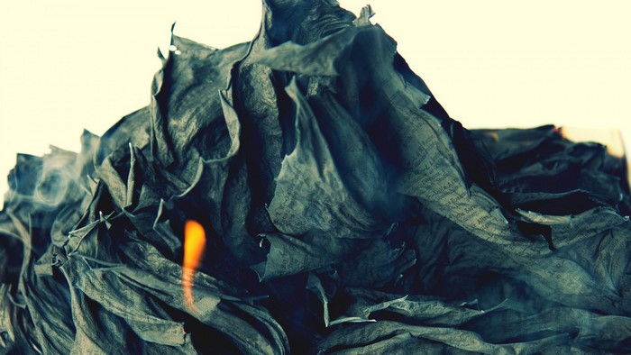 Burning crumpled paper with text