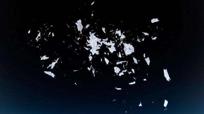 Scattered white fragments on a dark background