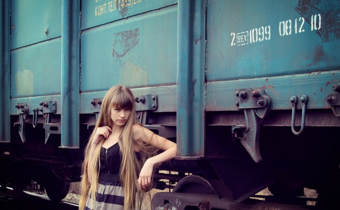 Woman posing by a blue train car
