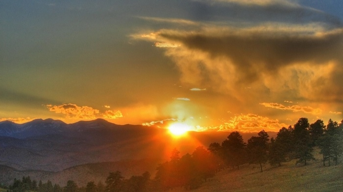 Sunset over mountains and trees
