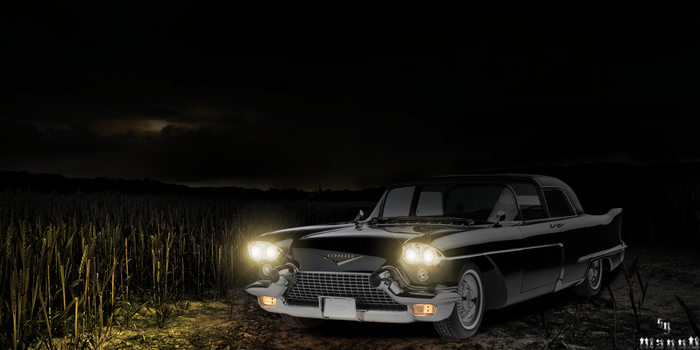 Vintage black Cadillac in a field at night
