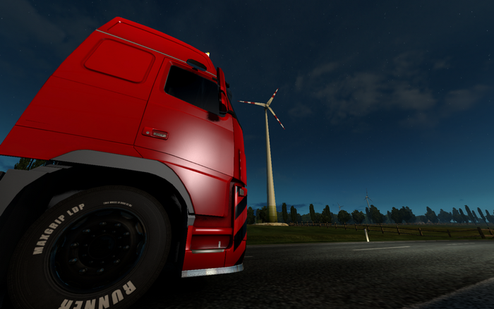 Red truck at night with wind turbines in Euro Truck Simulator 2