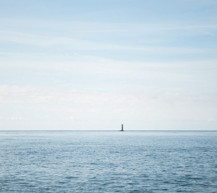 Lighthouse on the horizon over the ocean