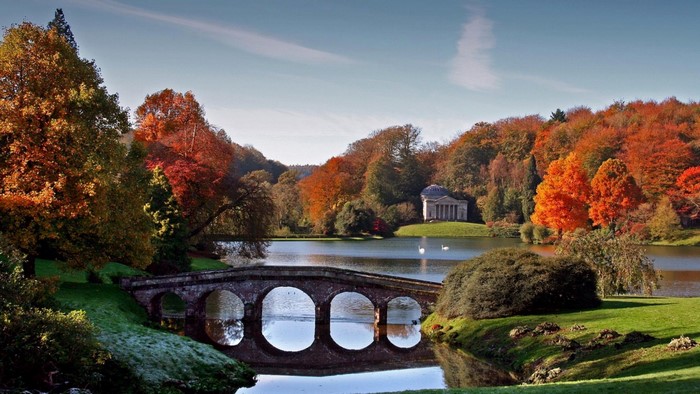 Autumn landscape with a stone bridge and a classical temple