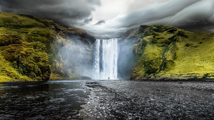 Skogafoss Waterfall in Iceland with a lone figure