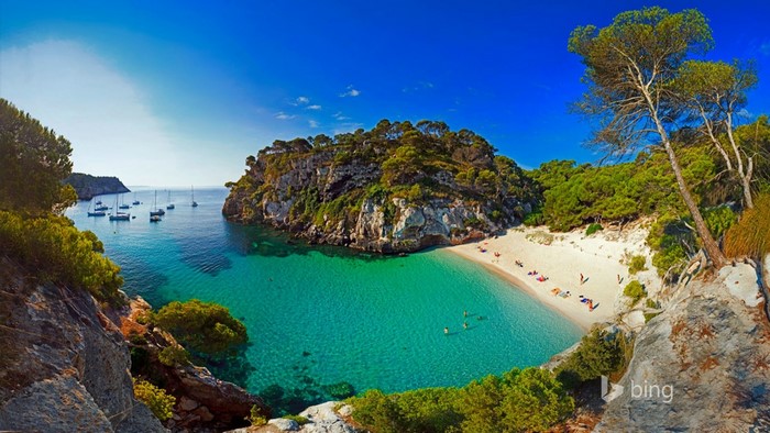 Scenic bay with sailboats and a sandy beach