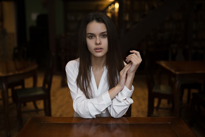 Woman in white shirt sitting at a table