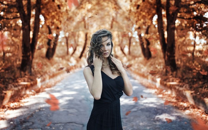 Woman in black dress on autumn road