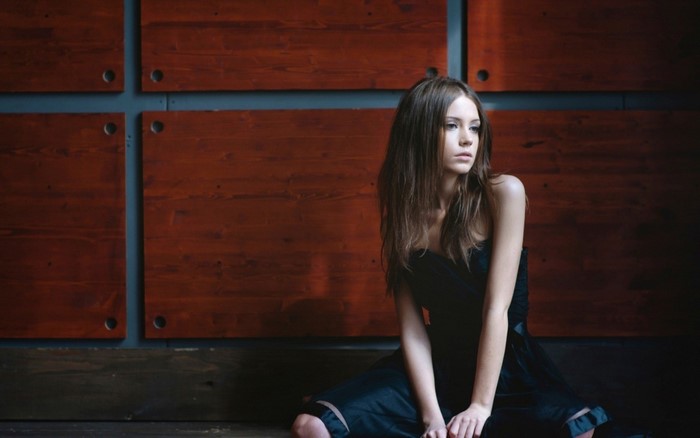 Woman in black dress sitting on floor
