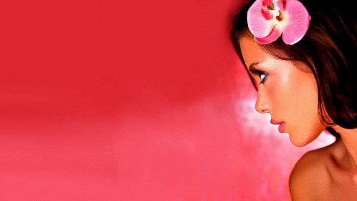 Woman with pink orchid in her hair