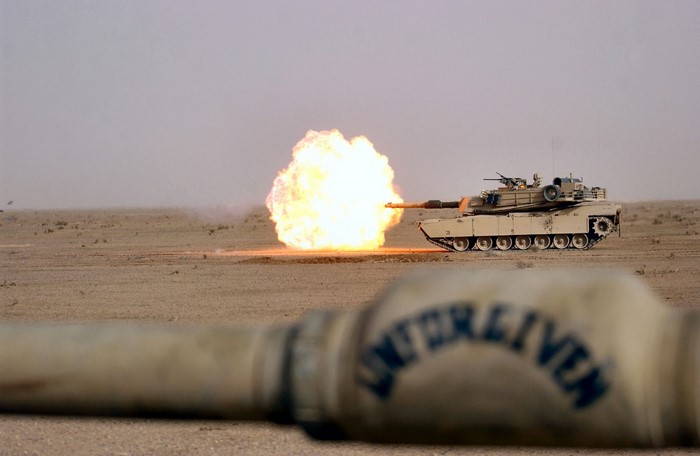 M1 Abrams tank firing a round in a desert