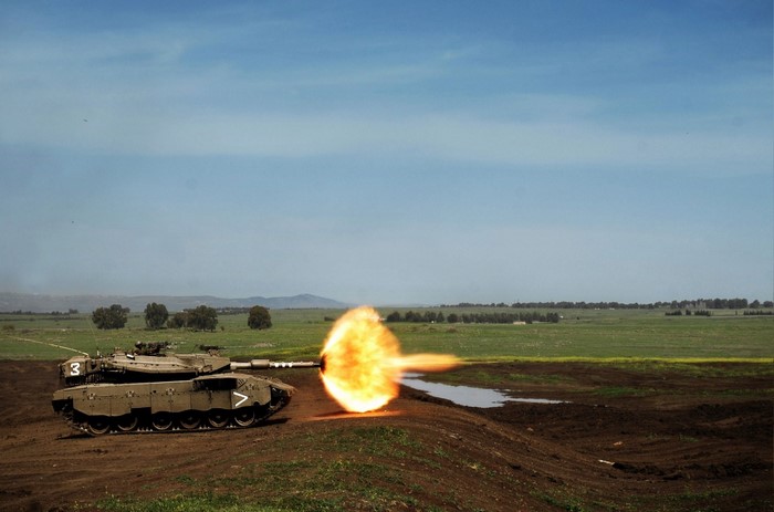 Merkava tank firing a projectile in a field